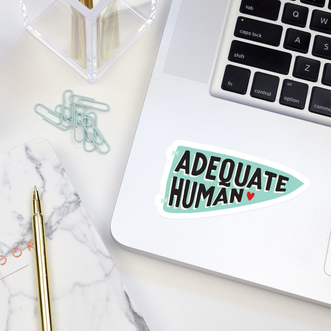 Adequate human vinyl sticker on laptop