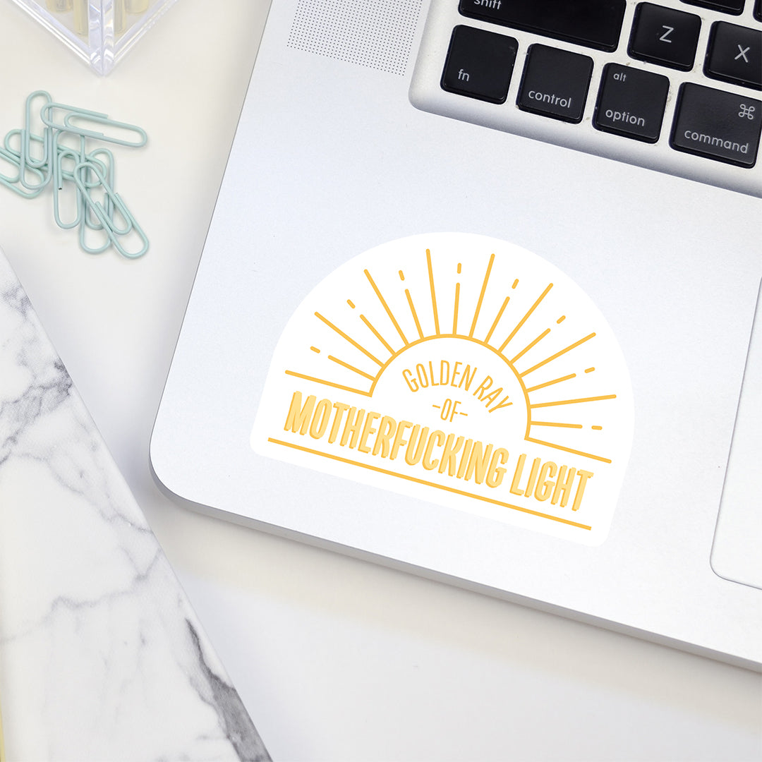 Golden ray of MF light vinyl sticker on laptop
